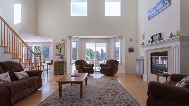 A spacious living room with a high ceiling, a fireplace, and a large window overlooking a garden. - Perfect For Large Family Get Aways Or Your Gorgeous Ranch Style Wedding. (Arroyo Grande)