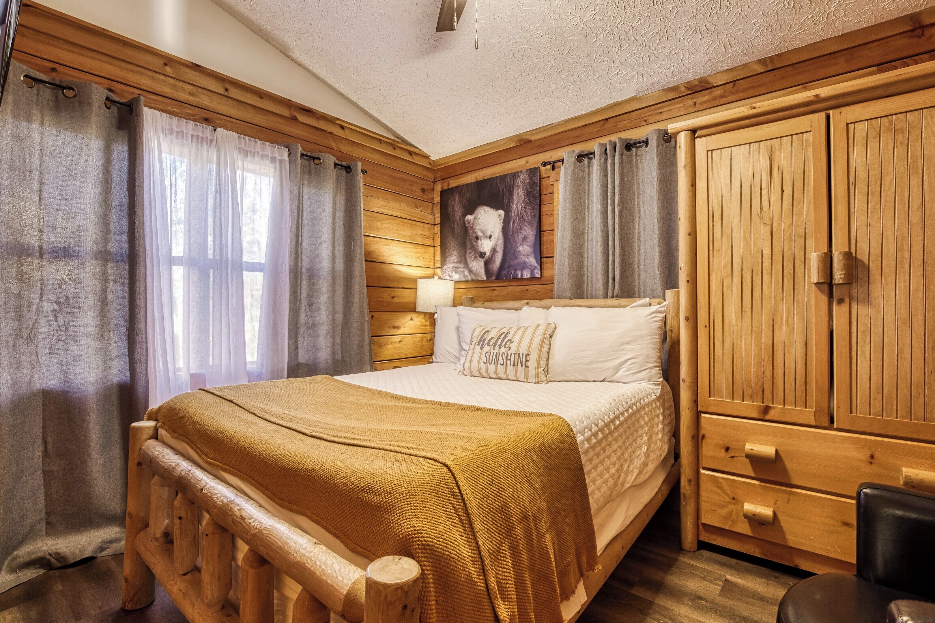 Un dormitorio con paneles de madera, una cama, una mesita de noche, una lámpara y un armario.