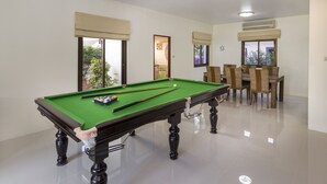 A pool table with a green felt surface, surrounded by a dining area with chairs and a table. - RATANA VILLA - PATTAYA HOLIDAY HOUSE - WALKING STREET (Muang Pattaya)