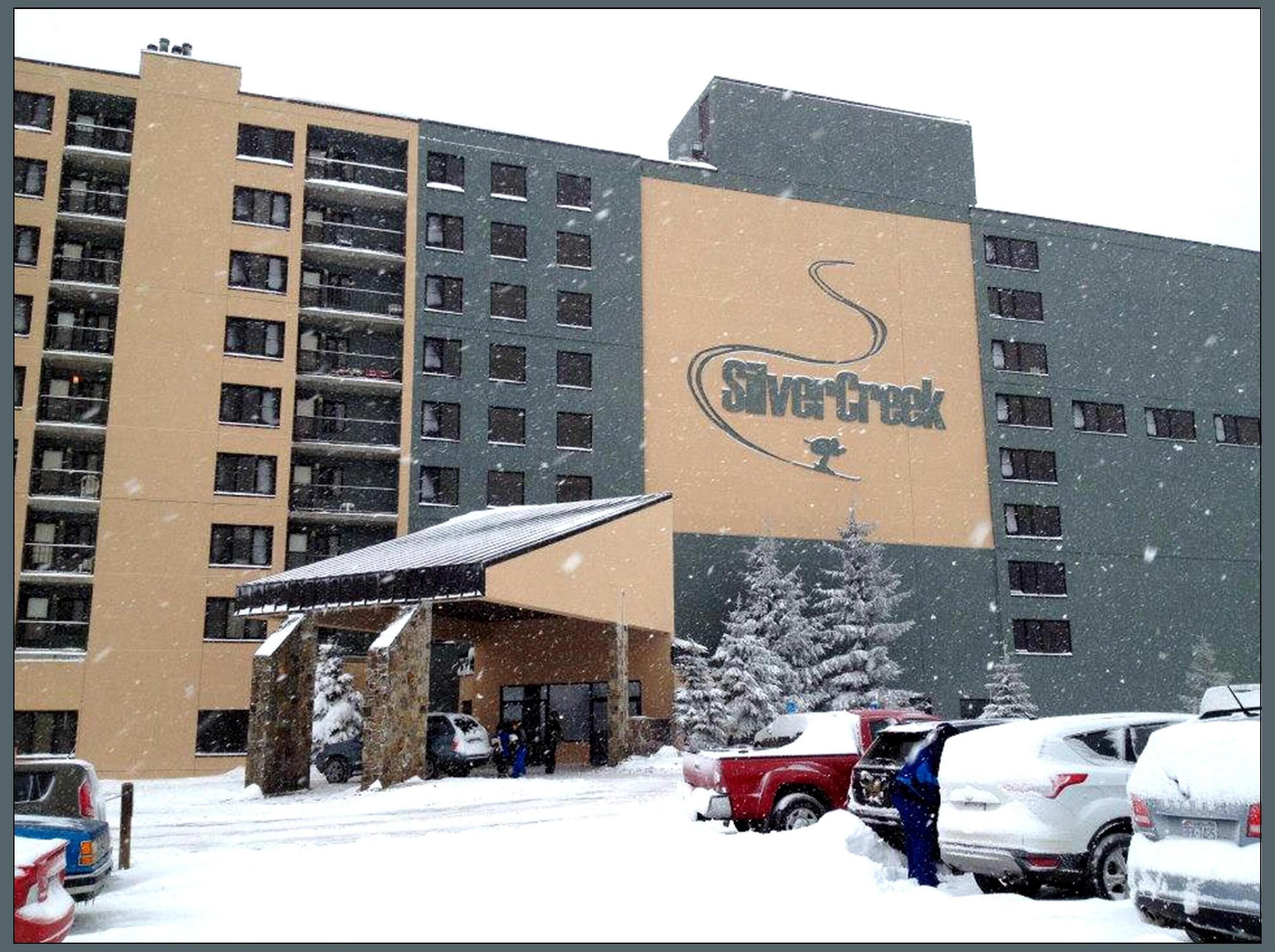 Un hotel con un letrero grande que dice "Silver Creek" y una entrada cubierta.