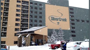 Un hotel con un letrero grande que dice "Silver Creek" y una entrada cubierta.