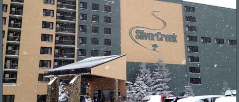 Un hotel con un letrero grande que dice "Silver Creek" y una entrada cubierta.
