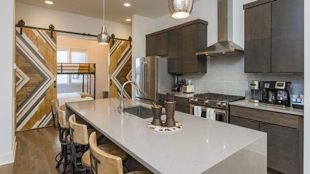 A modern kitchen with a large island, stainless steel appliances, and a stylish pendant light. - Rooftop+Downtown close*  Nashville mural* (Nashville)
