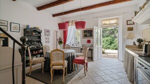 Un espace repas comprenant une table, des chaises et un coin cuisine équipé d’une cuisinière.