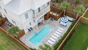 A two-story house with a swimming pool, outdoor seating, and a fenced garden area. - Snazzy Coconut | Private Pool | Game Room | Private Beach Access (Miramar Beach)
