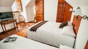 A bedroom with a bed, a desk, a chair, and a television. - Abadía Apartment, Rectoral of Areas (Tuy)