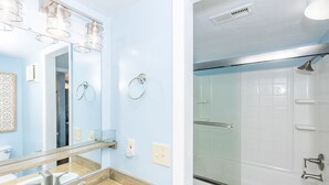 Une salle de bain avec un miroir, un lavabo et une douche.