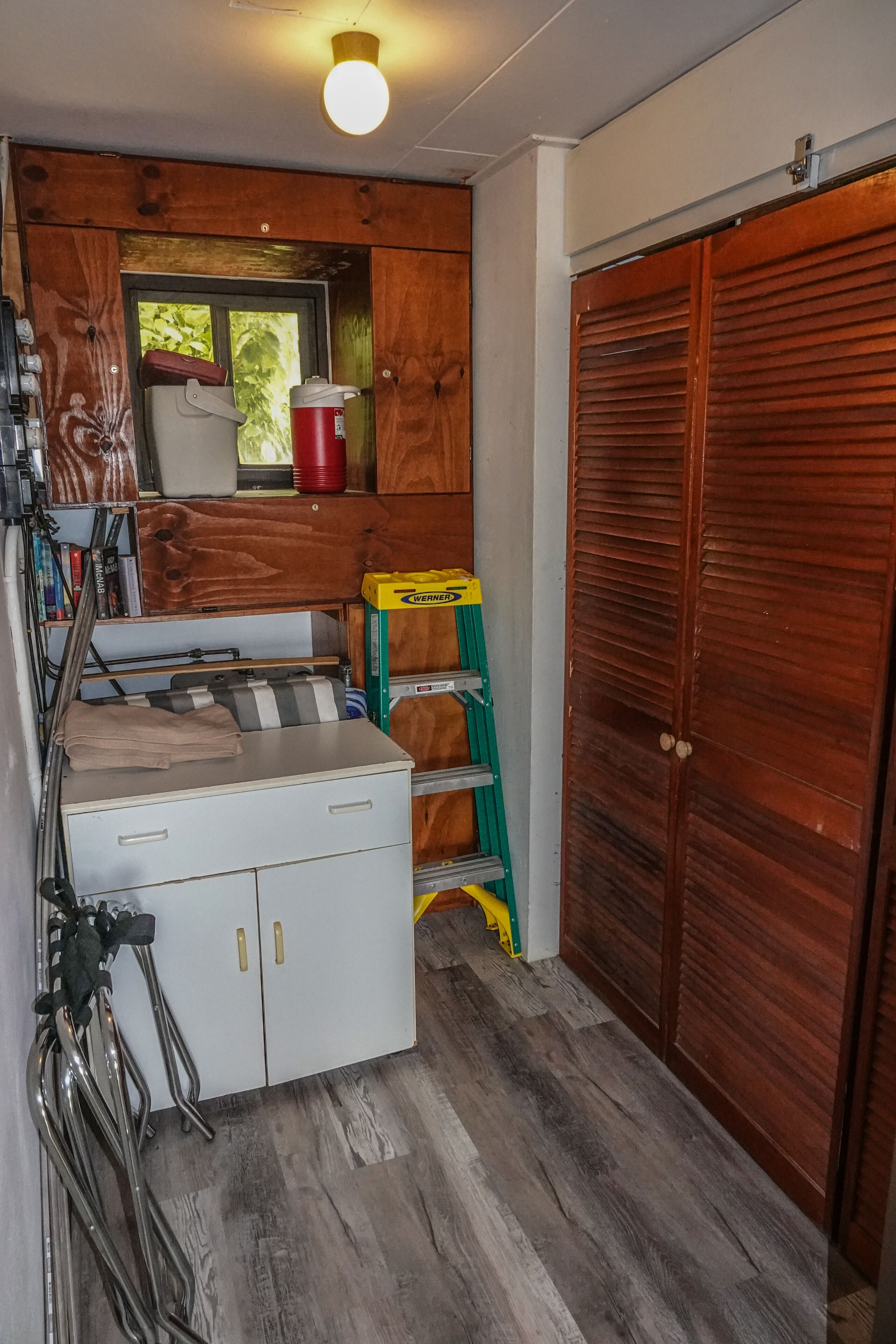 A compact kitchen with wooden cabinets, a refrigerator, and a window with a view.