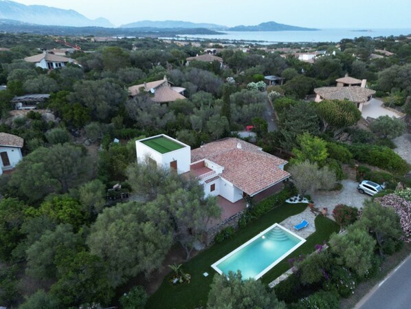 An aerial view of a residential area with houses, a swimming pool, and a view of the sea. - VILLA LU IMPOSTU swimming pool, sea view, 5bathrooms, terrace, garden, solarium (San Teodoro)
