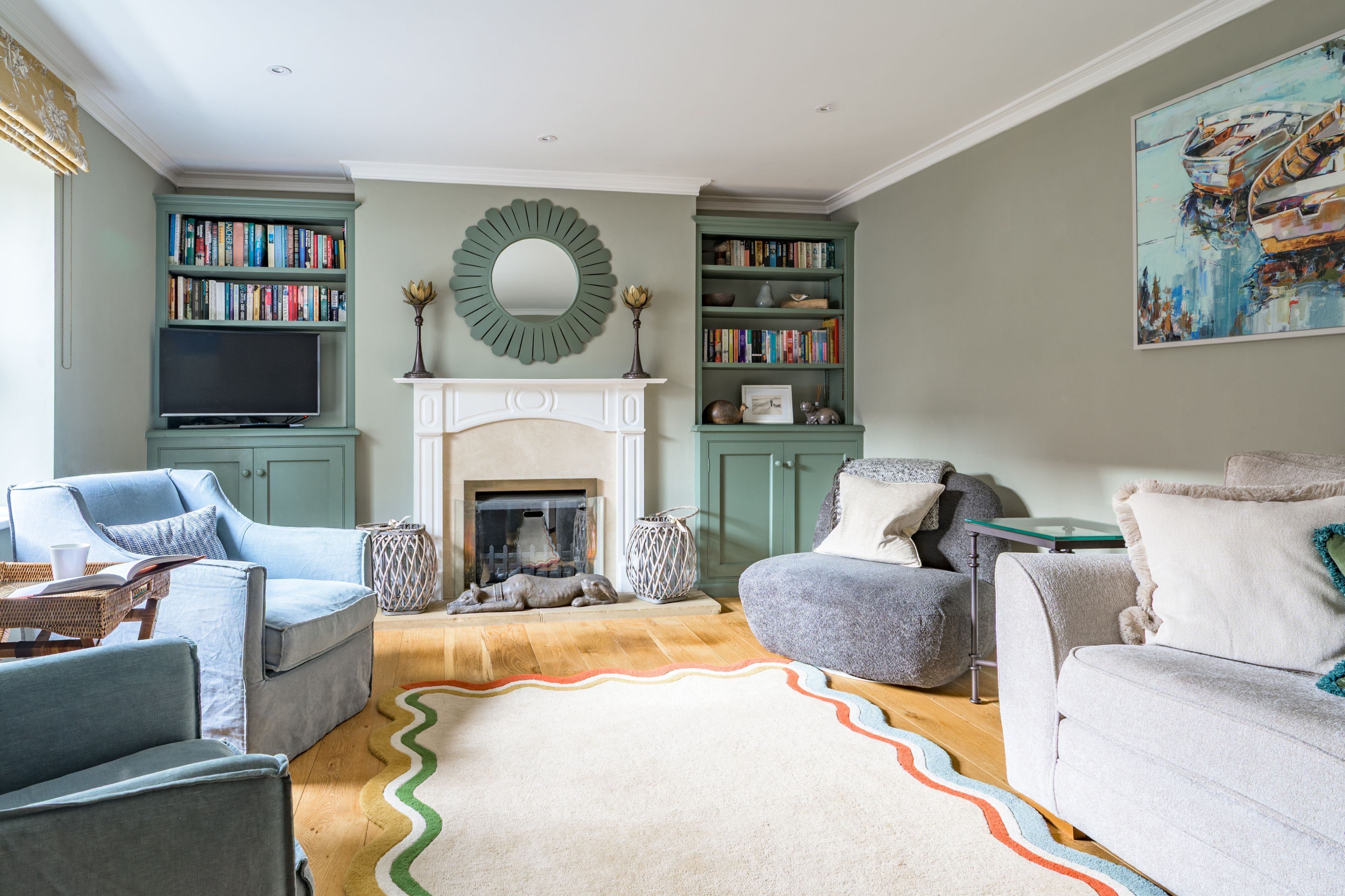 A living room with a fireplace, bookshelves, and a television.