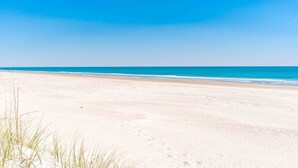 A beach with a clear sky and calm sea.
