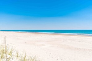 Une plage avec un ciel dégagé et une mer calme.