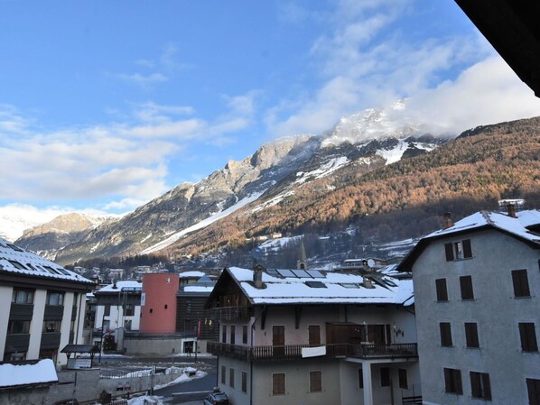 A mountain town with snow-covered buildings and a prominent red tower.