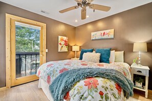 A bedroom with a bed, a ceiling fan, a nightstand, and a window with a view of trees. - SKI N SKI OUT. 5 Min Walk to Historic Main St.  Ski, Hike, Bike,  out the door. (Park City)