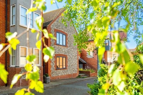 Ein zweistöckiges Haus mit Sandsteinfassade, einem sichtbaren Fenster und einer Ziegelverkleidung.