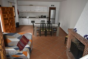 A compact living space with a dining area, kitchenette, and a fireplace.