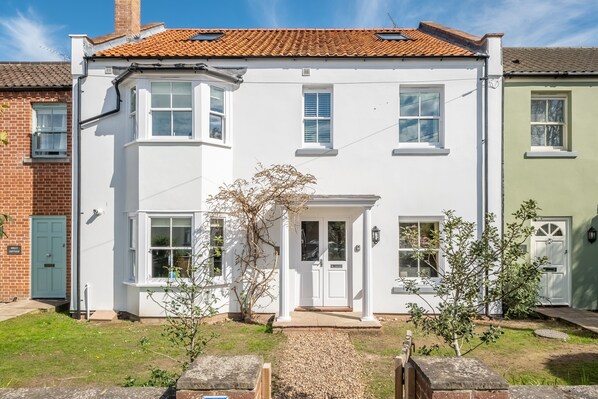 A two-story white house with a red-tiled roof, a front porch, and a small garden area. - Holly House, Wells-next-the-Sea, Norfolk (Wells-Next-The-Sea)