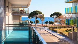 A modern building with a glass balcony overlooking a beach. - Apartment in Family Complex 50m beach · UHC MAR AUGUSTA 212 (Cambrils)