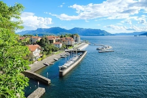 Un port de plaisance situé au bord de l’eau, avec des bateaux amarrés, une jetée s’avançant dans l’eau et des bâtiments le long de la rive.