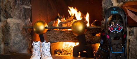 A fireplace with a stone arch, a pair of boots, and a bicycle helmet with "TUBBS" and "FLEX RDG" visible.