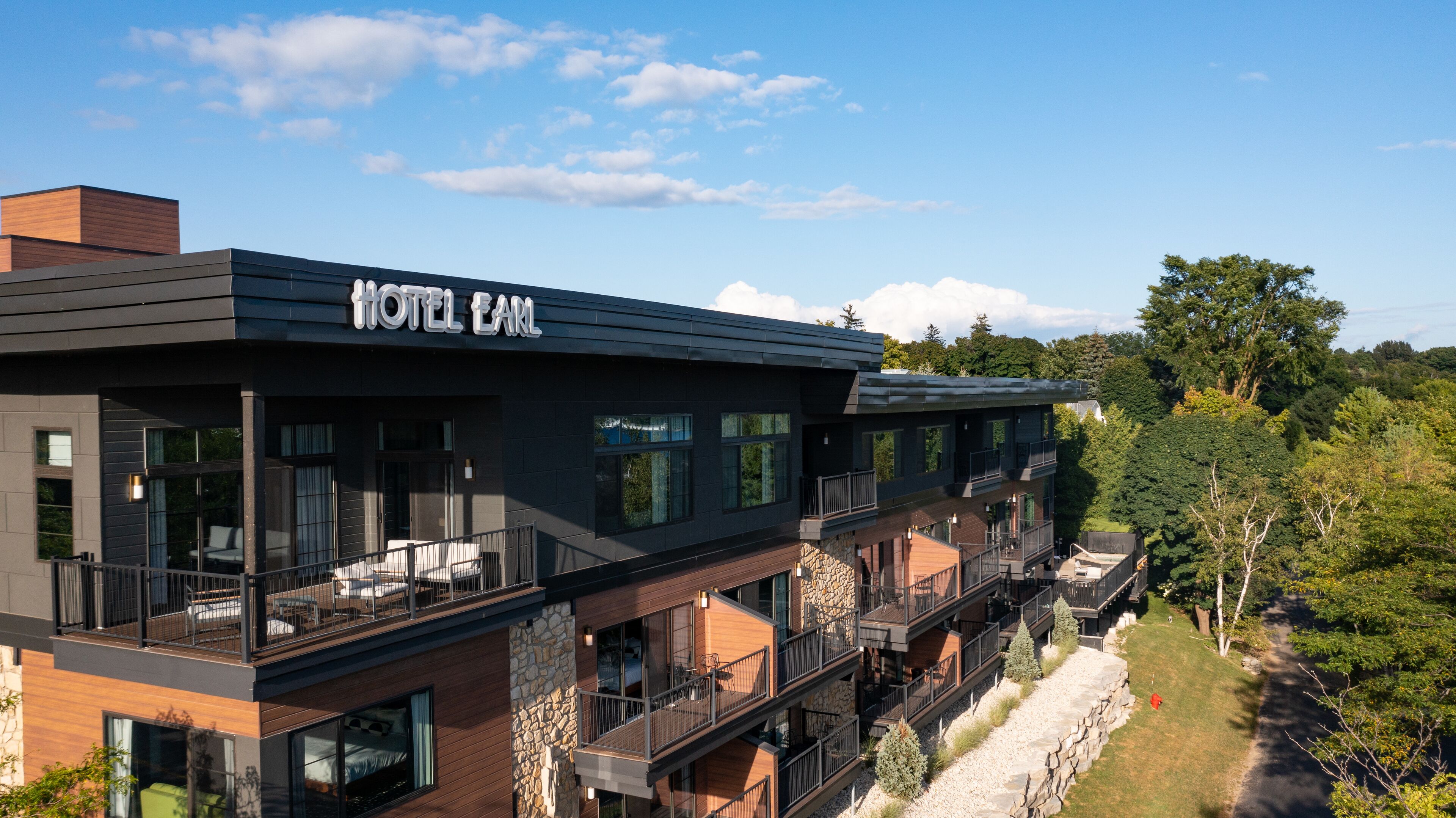 Un hôtel moderne doté d’un toit plat, de grandes fenêtres et d’une enseigne indiquant « HÔTEL EARL ».