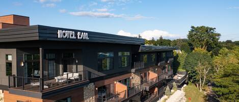 Un hôtel moderne doté d’un toit plat, de grandes fenêtres et d’une enseigne indiquant « HÔTEL EARL ».