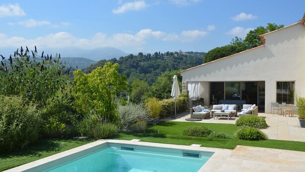 A modern house with a swimming pool, outdoor seating, and a view of the countryside. - Peaceful designed modern villa nestles in St Paul de Vence (saint paul de vence)