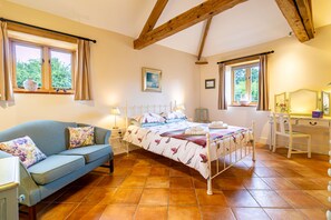 Un dormitorio con cama, sofá, escritorio y ventana.