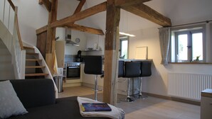 A modern kitchen with a stove, oven, and bar stools. - Apartment on the Elbe dyke in Radegast I (Bleckede)