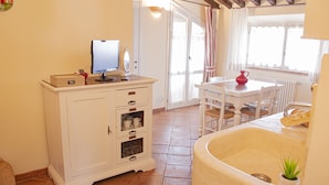 Una cocina con un armario blanco, una mesa de comedor y un lavamanos.