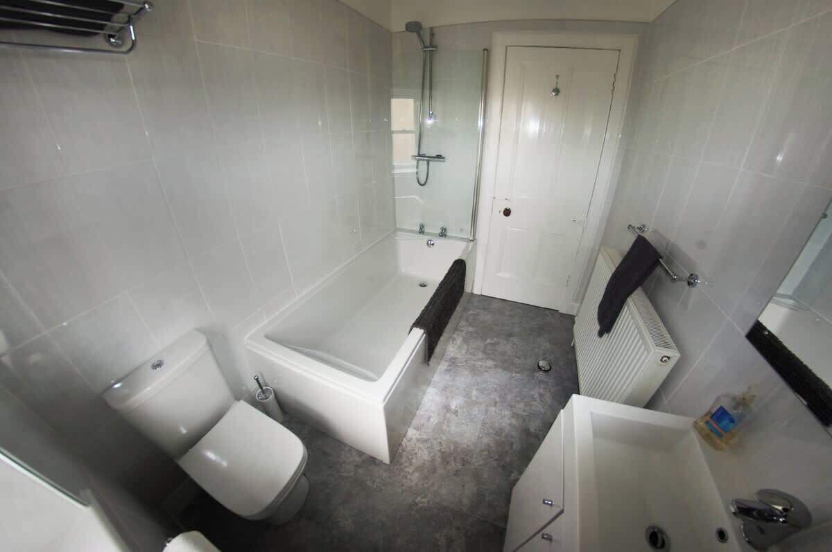Une salle de bain avec une baignoire, des toilettes et une douche.