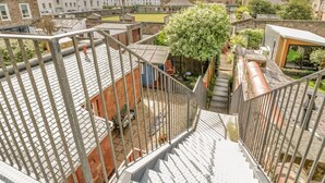 A residential area with a staircase leading to a rooftop garden, surrounded by buildings with a mix of architectural styles. - Ayr Beach View Apartment (Ayr)