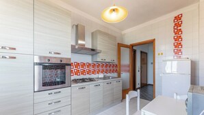 A modern kitchen with stainless steel appliances, a dining area with a white table and chairs, and a patterned backsplash. - Cozy apartment Blue Sunset sea view in Gallipoli CVG42 (Gallipoli)