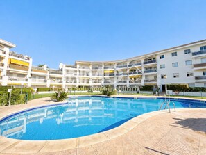 A residential building with a swimming pool, balconies, and a clear sky. - On the beach front - Edif. Olimpic in La Llosa (Cambrils)