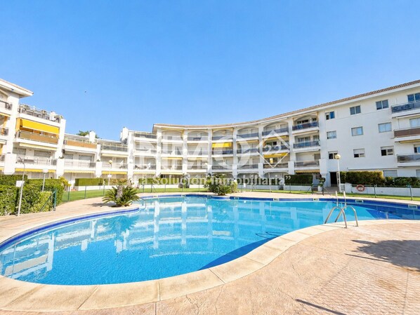 A residential building with a swimming pool, balconies, and a clear sky. - On the beach front - Edif. Olimpic in La Llosa (Cambrils)