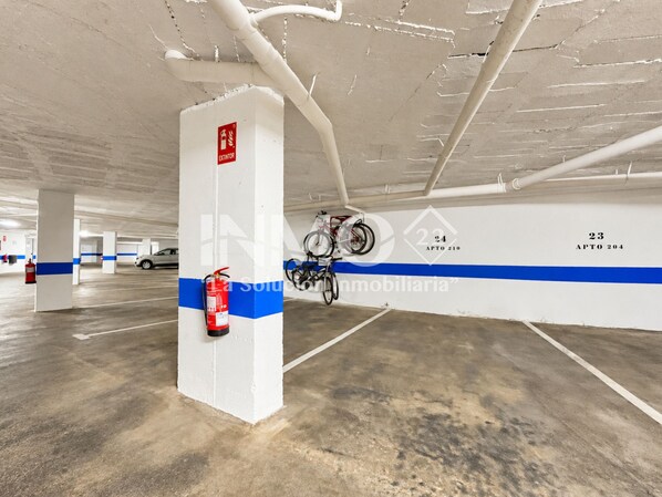 A parking garage with white pillars, blue stripes, and numbered parking spaces.
