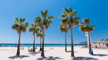 Una playa cerca, sillas reclinables de playa, toallas de playa