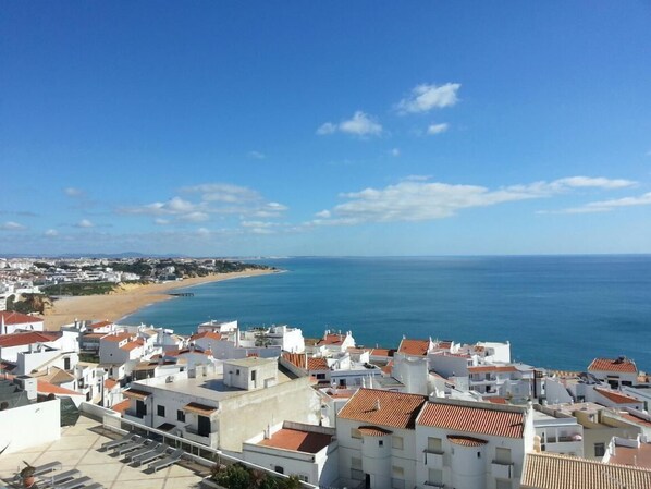 Une ville côtière aux bâtiments blancs, avec une plage et la mer.