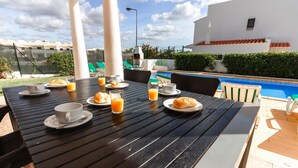 A dining table with breakfast items and a poolside view. -  5min walking distance from amenities and beach , Private Swimming Pool, wifi (Albufeira)