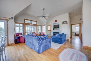 A spacious living area with a large sofa, a television, and a fireplace.