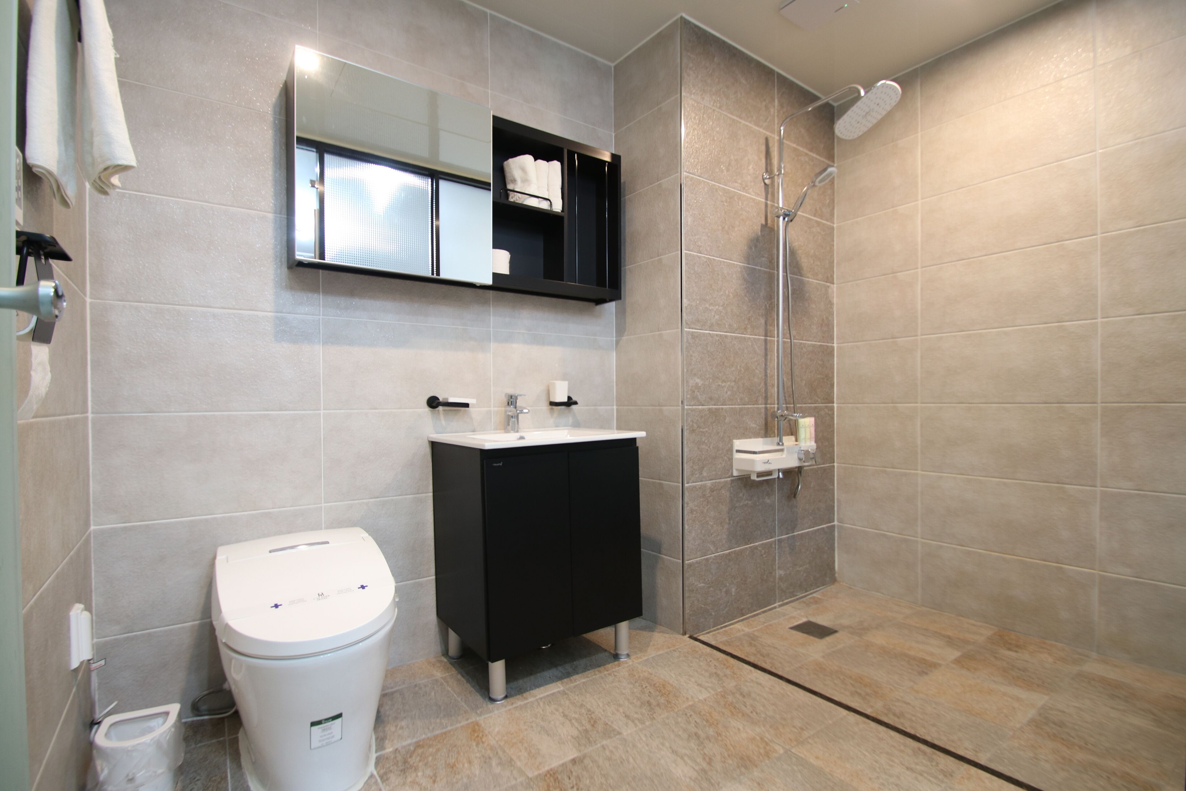 A modern bathroom with a toilet, sink, and shower.