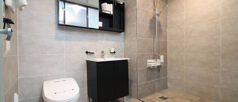 A modern bathroom with a toilet, sink, and shower.