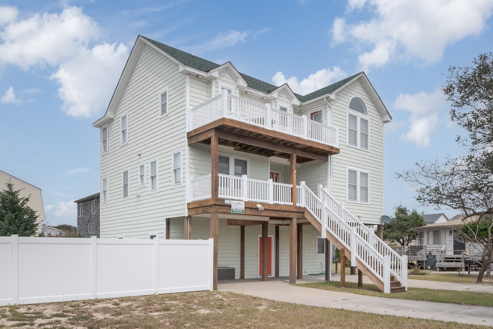A two-story building with a balcony and a staircase leading to the entrance.