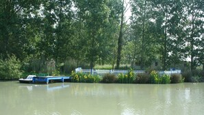 Une rivière paisible, avec un bateau amarré sur la rive gauche.