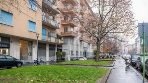 Una calle residencial con edificios de apartamentos, aceras y coches estacionados.