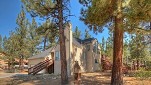A two-story building with a wooden staircase leading to a covered porch. - PET FRIENDLY! Expansive Game Room with Pool Table, Ping Pong, Air Hockey & more! HOT TUB! Walk to Lake! (Big Bear Lake)