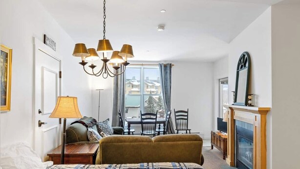 Un dormitorio acogedor con cama, escritorio, sillón, chimenea y ventana con cortinas.