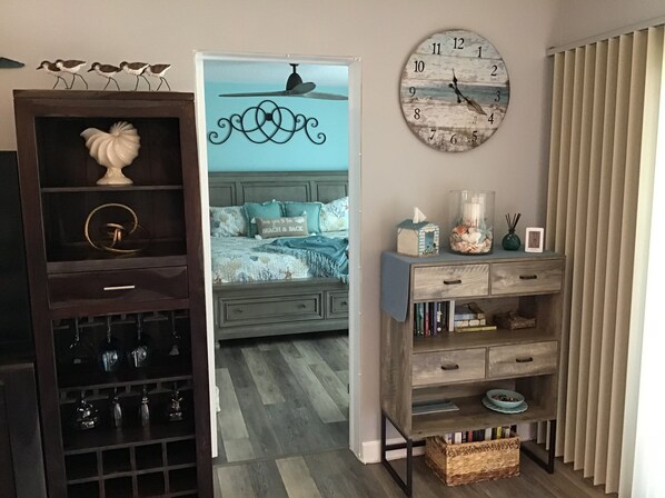 A bedroom with a bed, bedside table, and a wall clock.