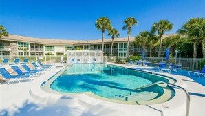 Ein Poolbereich mit Liegestühlen und Palmen.