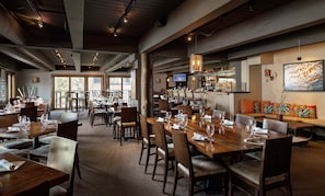 A restaurant with multiple dining tables, chairs, a bar area, and a large window providing a view. - 🌲Timberline C1A Deluxe 3-Bedroom ~Hot Tub~Pool~WiFi~Ski-in/out~Local Shuttle🌲 (Snowmass Village)